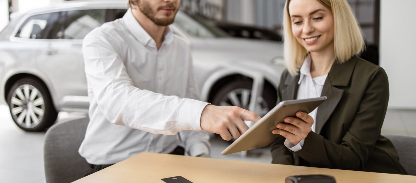 Businessman choosing auto, buying new automobile in car showroom.